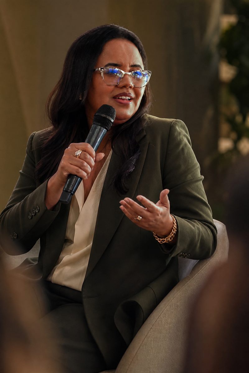 Maristela Oliveira com microfone durante uma palestra